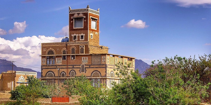 A building in Sana'a with a typical exterior design is standing tall under the blue sky