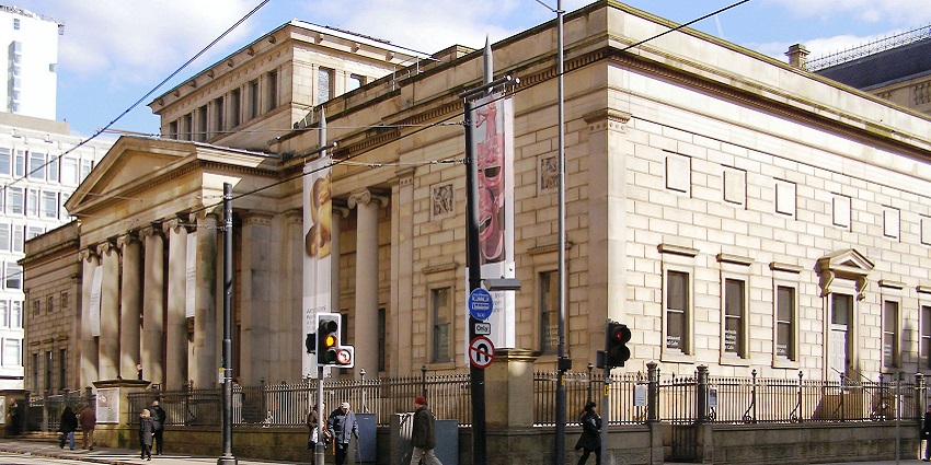 An image of Manchester Art Gallery, a neoclassical building with columns and banners.