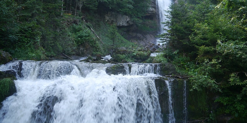 An image of the majestic Giessbach Waterfalls, surrounded by mountains and forests.