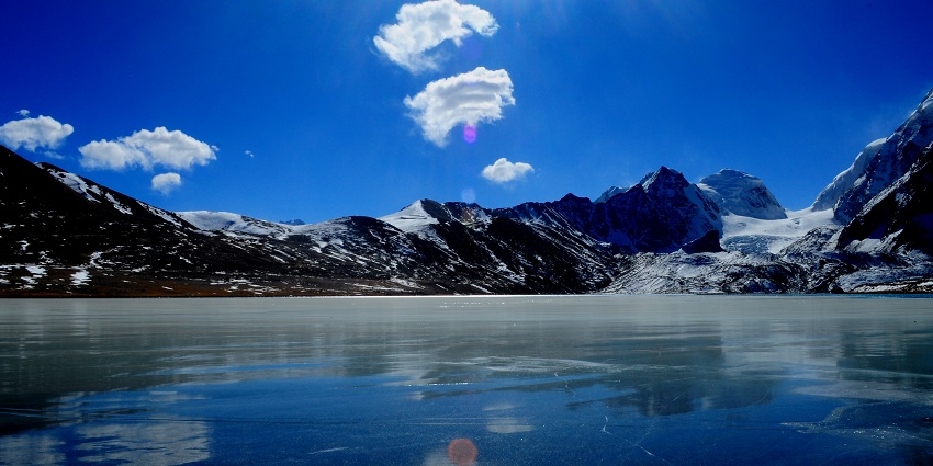 Sunshine shows visible cracks of freshly frozen Gurudongmar Lake in April.