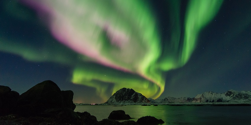 An image showing the breathtaking view of Lofoten, Norway, with northern lights in the sky