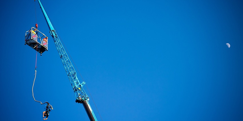 A man jumping, with a rope attached to a crane,, similar to bungee jumping in Lonavala