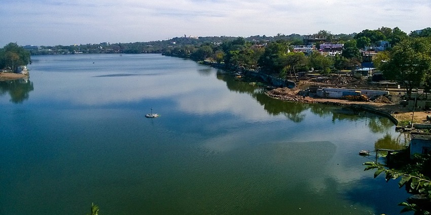 Lower lake with a small fountain in the middle of the lake and multiple buildings