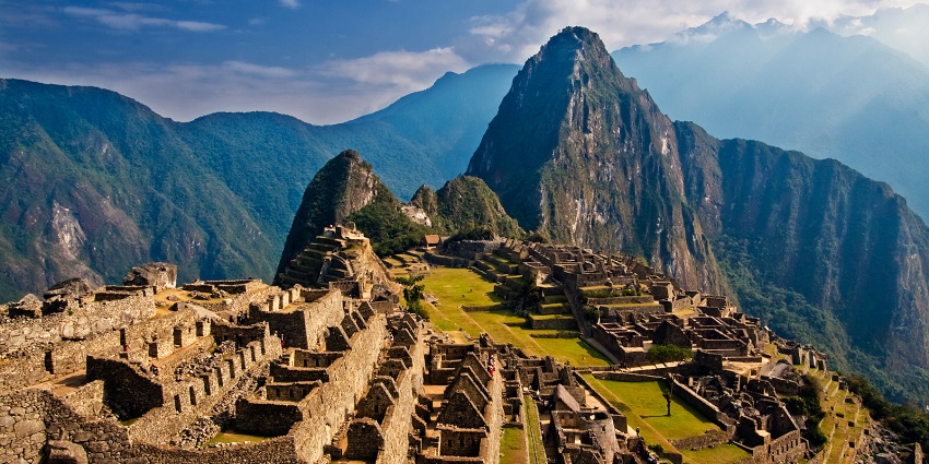 A panoramic view of Machu Picchu, with stone ruins set against the Andes mountains.