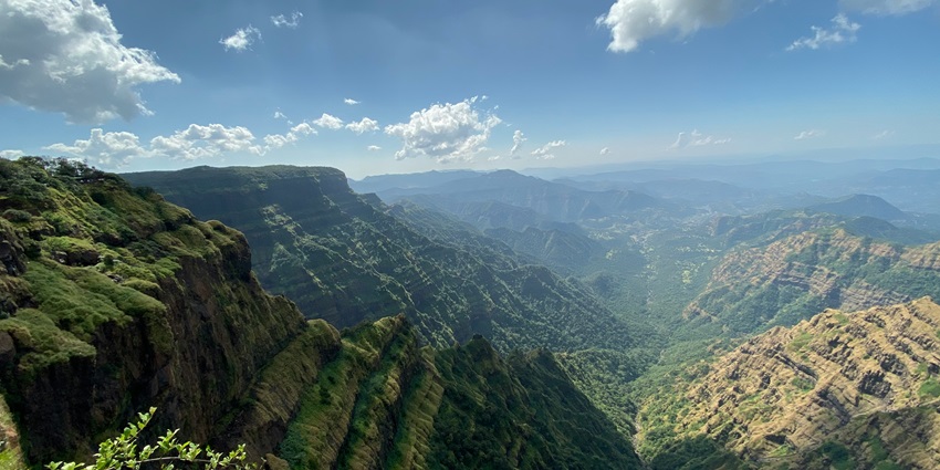 An image of Mahabaleshwar views, with lush green hills and valleys under a clear blue sky.