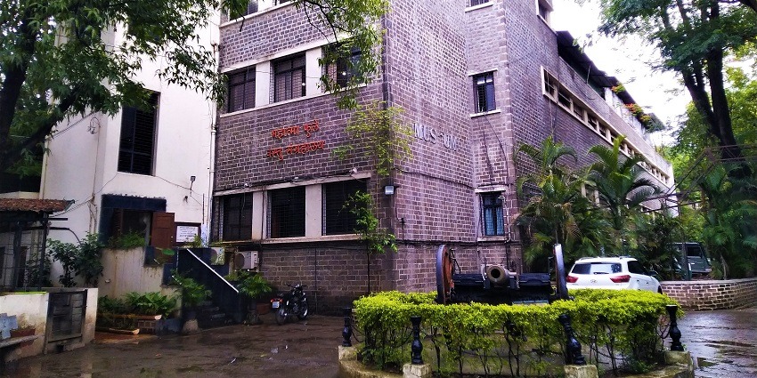 Mahatma Phule Vastu Sangrahalaya, with cars parked outside and a canon at the entrance.