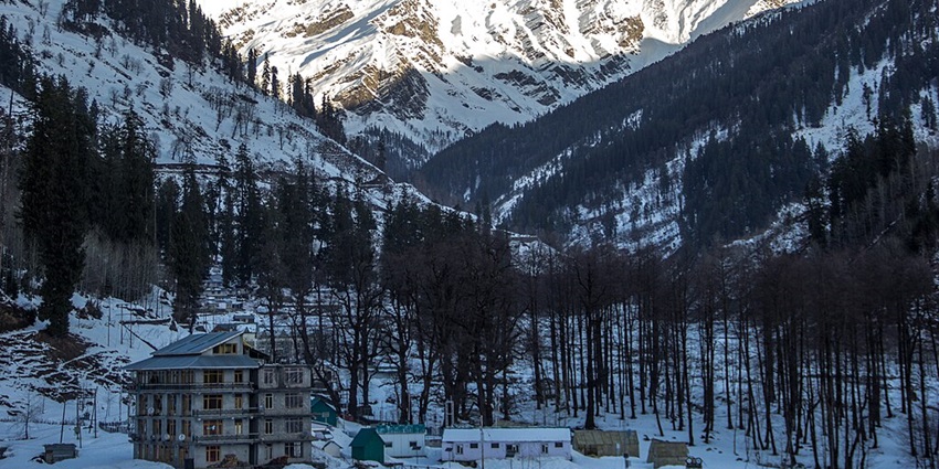 An image of snow-capped mountains and pine trees in Manali, one of the best places to visit in North India.