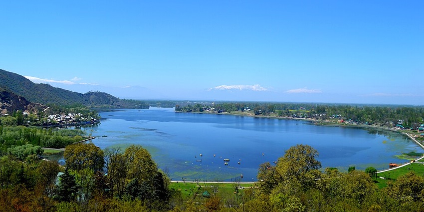 Manasbal Lake with boats and water circled by white borders, surrounded by green hills