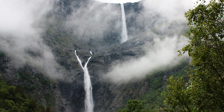 An Image of water flowing from the Mardalsfossen Waterfall, with mountain cliffs in the background.