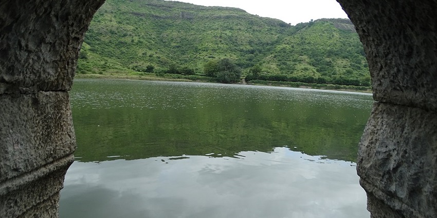 Lush green hills with a picturesque reservoir among the lakes in Pune