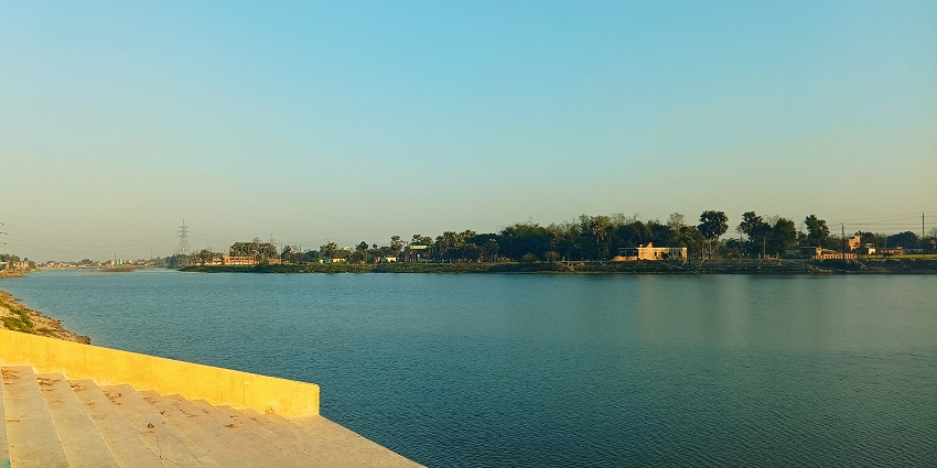 An image view of Matsyagandha Lake with calm waters, lush greenery, and a peaceful setting.