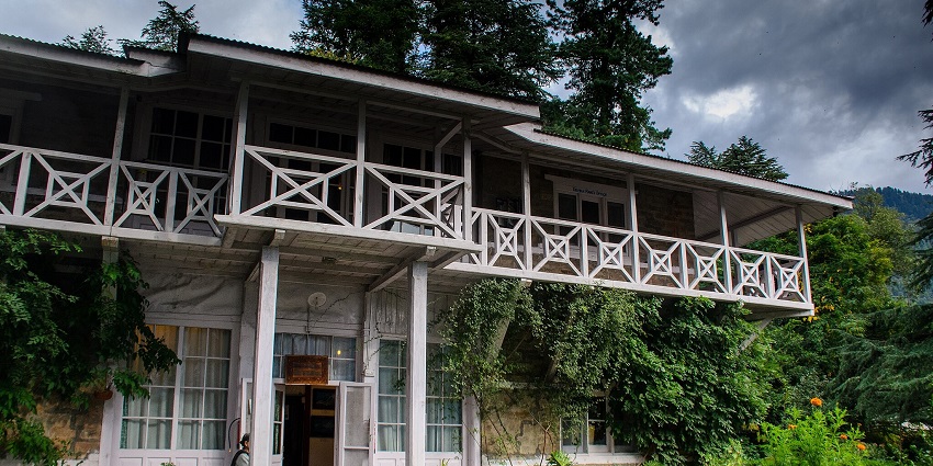 Image of an Ashram amidst lush greenery mountains with serene environment during day time