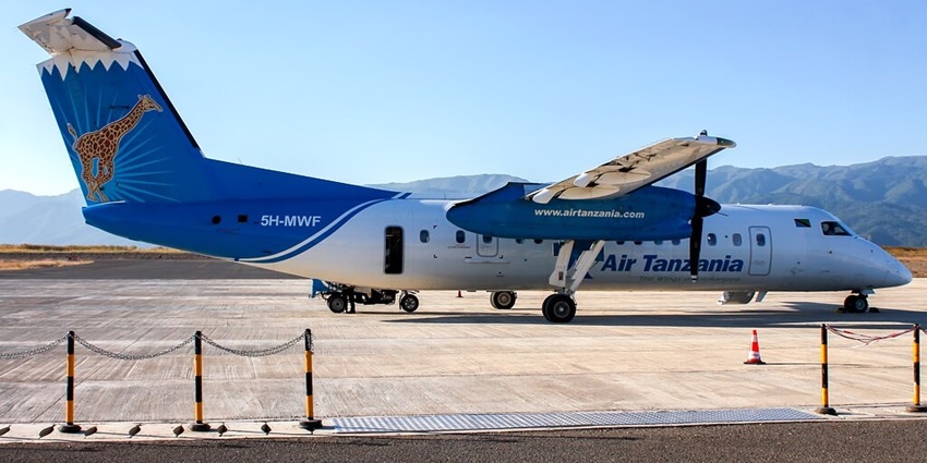 Songwe airport runway with a blue and white Air Tanzania plane surrounded by hills