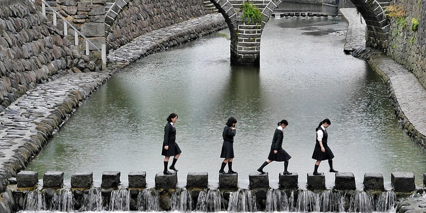A group of kids standing on Megane-bashi, the iconic ‘Spectacles Bridge’ in Japan.
