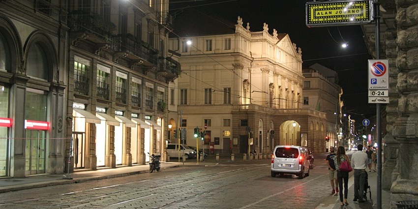 A nighttime view of a slightly busy street in Milan, Northern Italy.