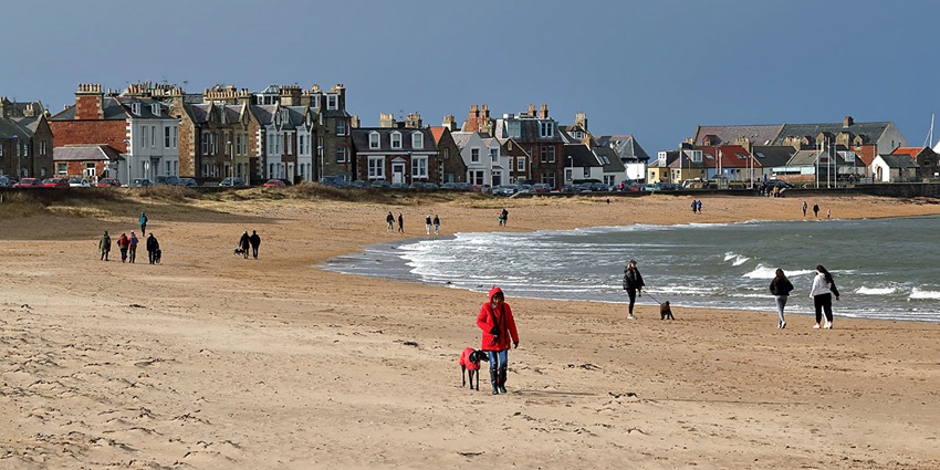 Tourists seen walking at the Milsey Bay beach, a family-friendly seaside destination.