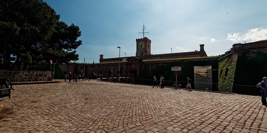 A wide view of Barcelona’s Montjuïc Castle shows visitors on a sunny day.