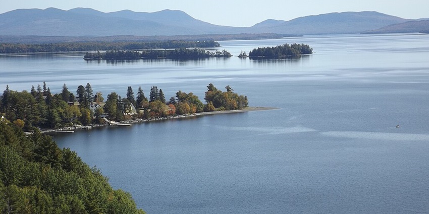 An aerial view of Moosehead Lake with misty hills in the background in Maine.
