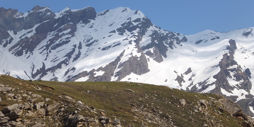 An image of a snow covered mountain in the background in Mundali, one of the best snowboarding in India.