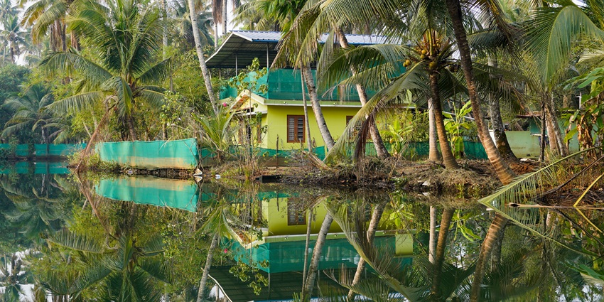 An image showing Munroe Island in Kollam district, Kerala, with houses by the canal.
