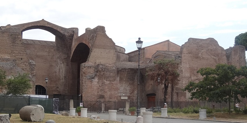 Ancient ruins of the Baths of Diocletian in Rome, with scattered stone fragments nearby