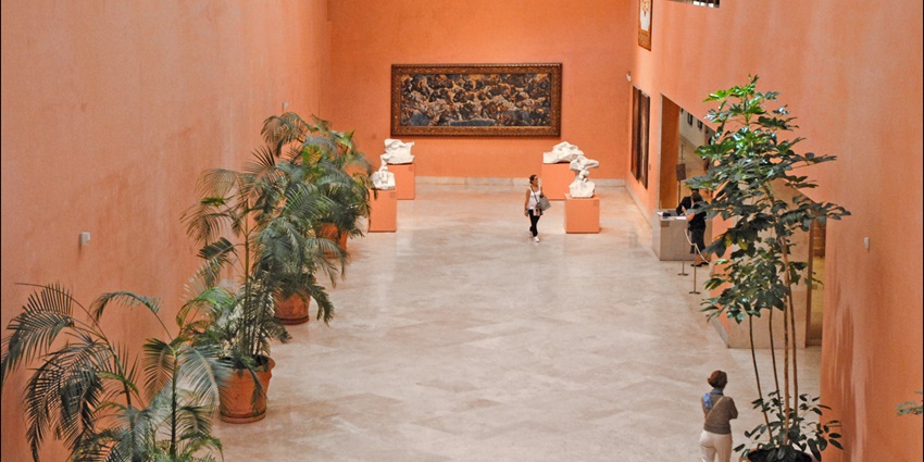Tourists glancing at important Spanish art at Thyssen-Bornemisza Museum in Madrid.