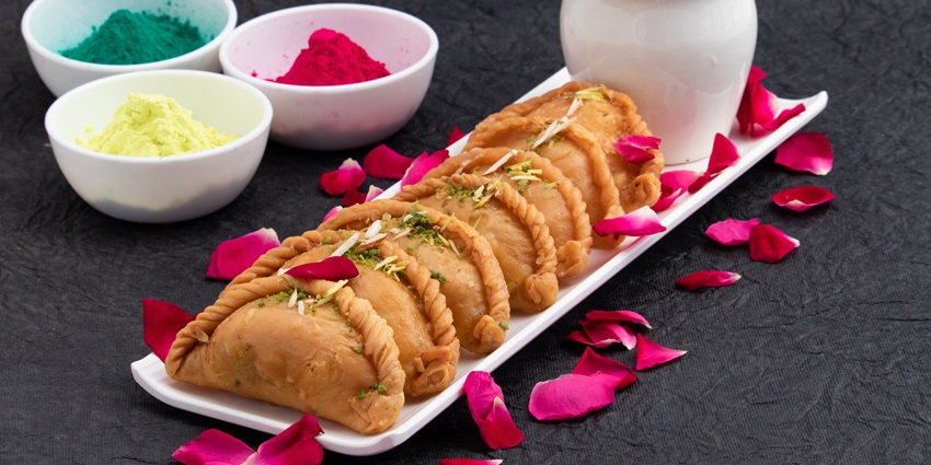 An image of a popular snack of Holi - Gujia, a crispy, deep-fried dumpling filled with khoya.