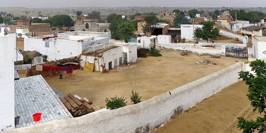 Rajasthan village from above with mud and cemented houses painted white and some trees