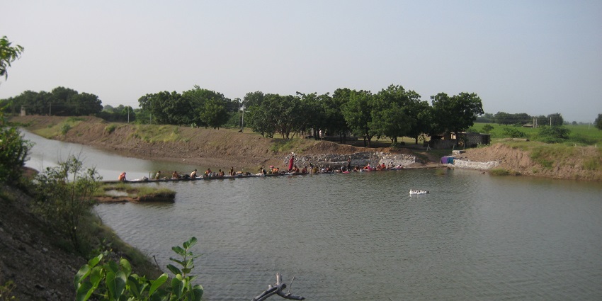 Narayan Sarovar in Dudhala with tranquil waters, surrounding temples, and a clear sky.