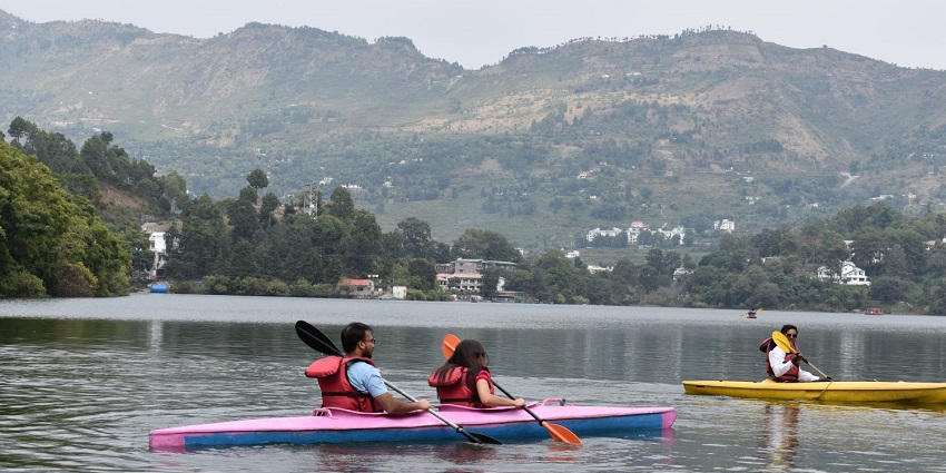 An image of Naukuchiatal Lake in Uttarakhand, featuring kayaking amidst scenic waters