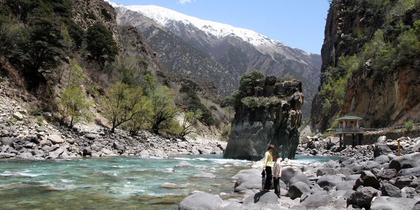 The Nyang Chu River flowing through a lush valley, surrounded by towering mountains