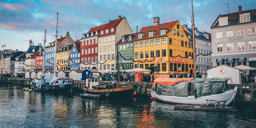 An image of Copenhagen's Nyhavn harbour, showcasing colourful buildings and docked boats.