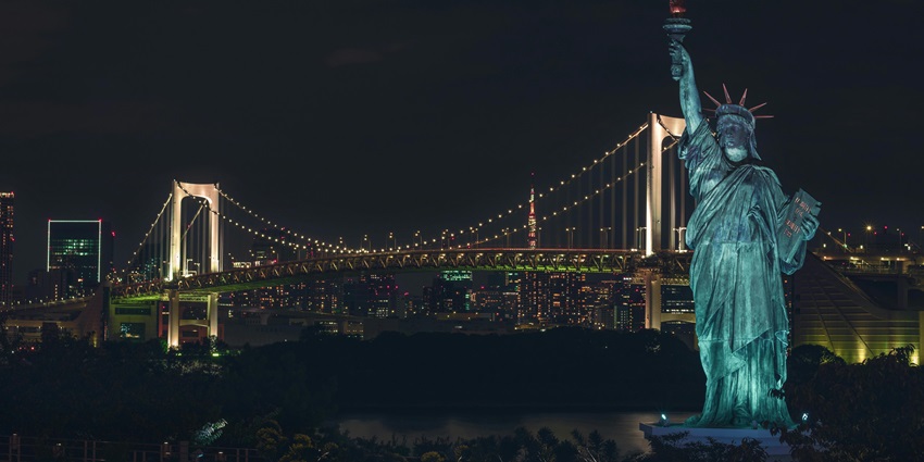 Illuminated Odaiba skyline seen from a night cruise, with Rainbow Bridge glowing brightly