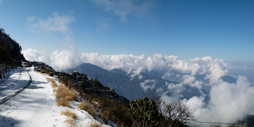 A breathtaking view of Zuluk featuring towering snow-clad mountains and pristine trails.