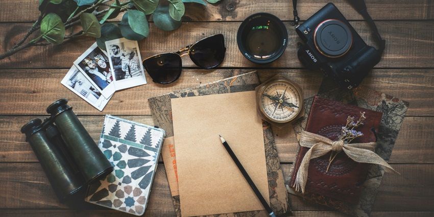 An image of the assorted travel items on the wooden table, important for your travel.