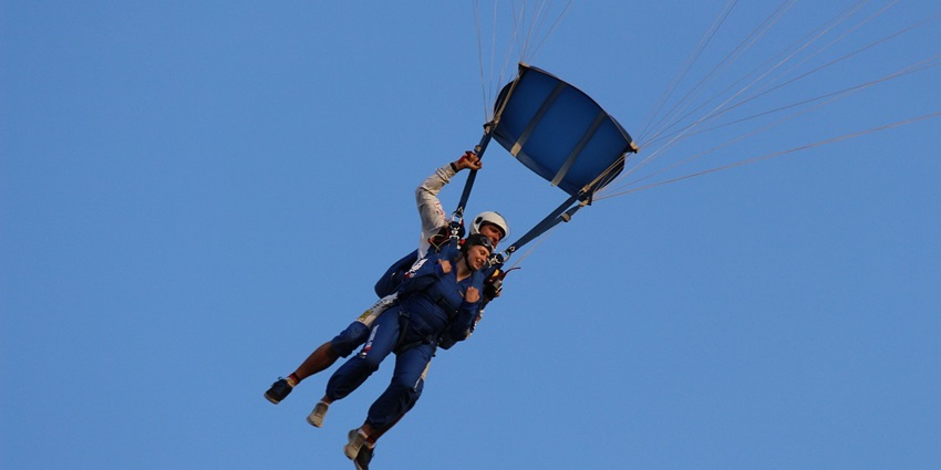 An image showing a person making a controlled leap with a parachute, similar to indoor skydiving in India.