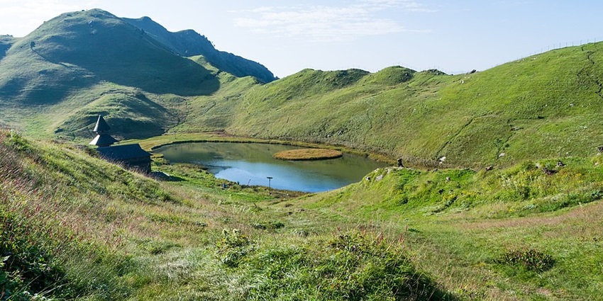 Prashar Lake in summer from the top of the mountains with a small water body and Prashar temple.