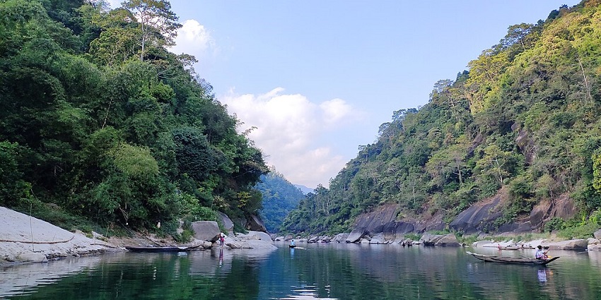 A serene view of the cleanest lake in Meghalaya with small boats docked along the shore.