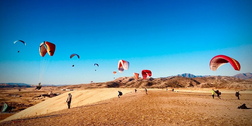 Tourists enjoying the adventurous sport of paragliding in Leh, Ladakh for an adrenaline rush