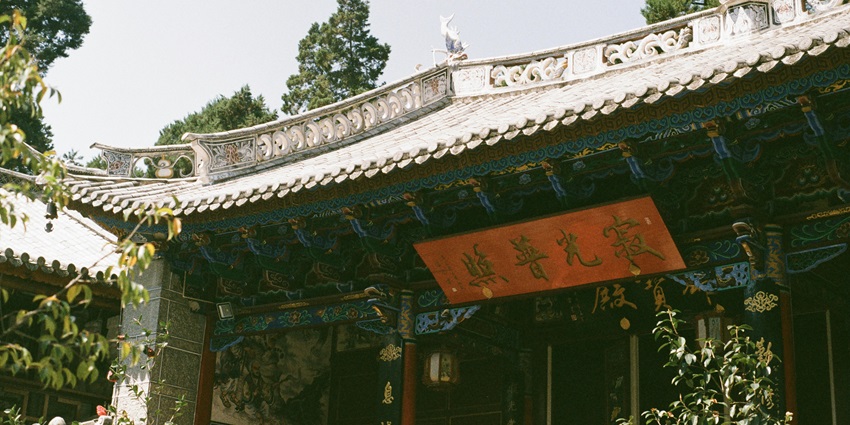 Exterior of a temple with intricate architecture, colorful details, and a clear blue sky