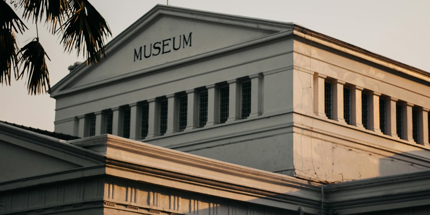 An image showing a low-angle view of a white museum during golden hour, resembling the Viking Museum.