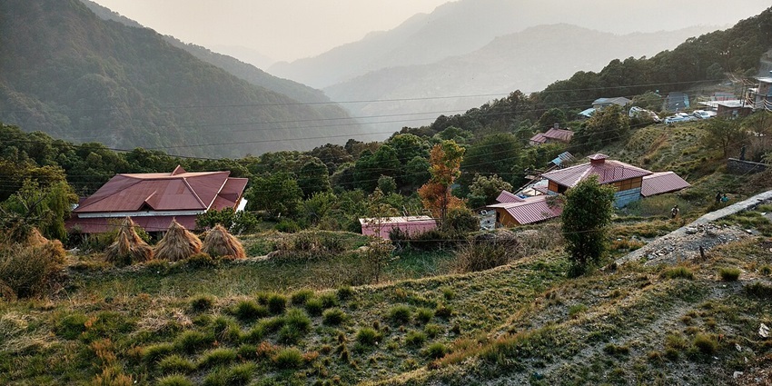A stunning view of the lush green valleys and a quaint little town in Pangot.