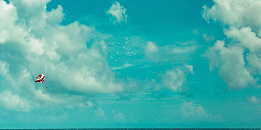 A beautiful picture of a parasailer gliding above the scenic landscape of Lonavala.