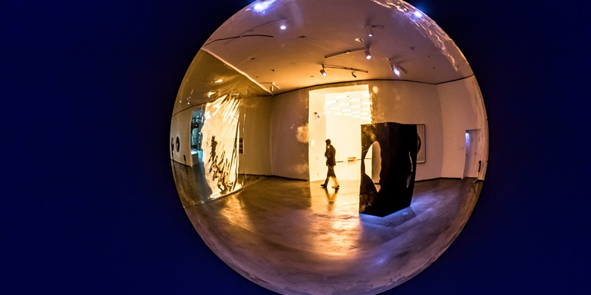 Visitors captivated by Renaissance art of glass ball reflection in an Art Museum in Italy