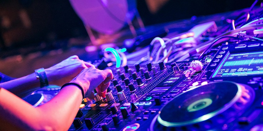 An image of the DJ booth of Penthouze Nightlife, with equipment set up and lights shining bright.