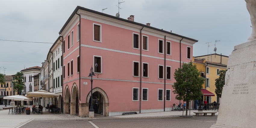 A beautiful pink building by the street in Piazza della Repubblica, one of the best places to visit in Florence.