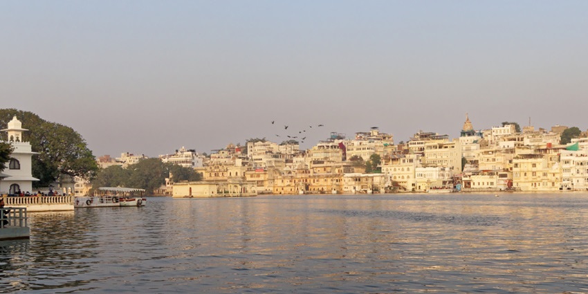 An image of Lake Pichola in Udaipur with calm waters and historic architecture.