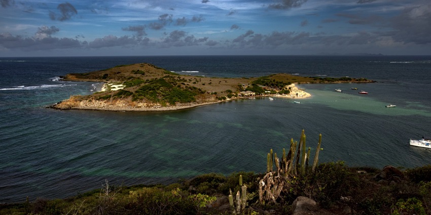 A beautiful, quiet beach with calm, shallow waters, accessible by boat.