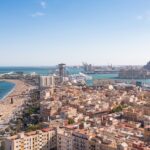 An aerial view of La Barceloneta’s lively beach on a sunny day in Barcelona, Spain.