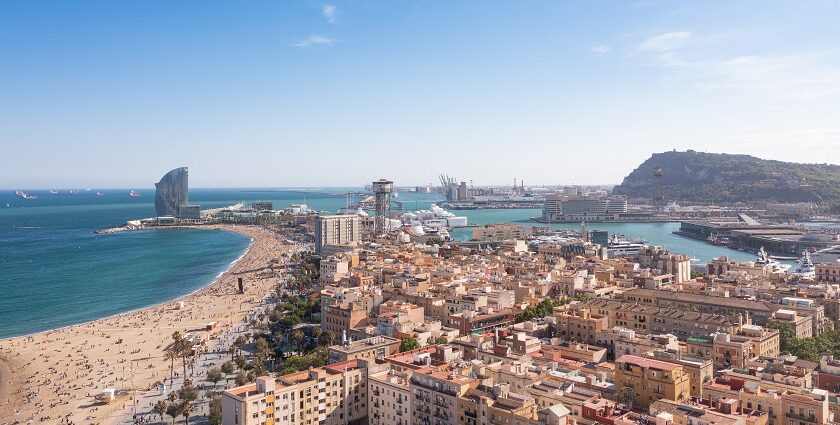 An aerial view of La Barceloneta’s lively beach on a sunny day in Barcelona, Spain.